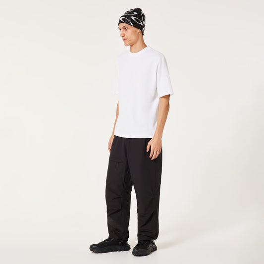 Person wearing a white t-shirt, black pants, and a patterned beanie on a white background