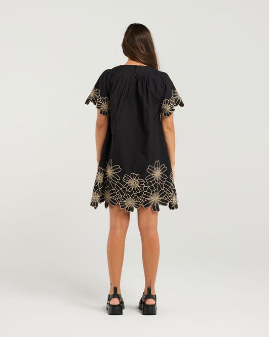 Black dress with gold floral embroidery on a white background