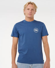 Man wearing a blue t-shirt with a logo on a white background