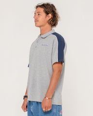 Person wearing a gray and navy polo shirt with a visible brand logo on a light background