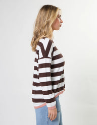 Woman wearing a brown and white striped sweater on a plain background