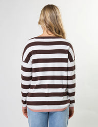Person wearing a brown and white striped sweater on a plain background