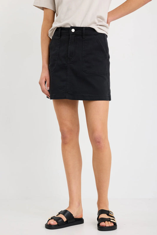 Person wearing a black denim skirt on a white background
