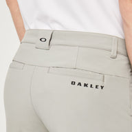 Close-up of light gray pants with 'Oakley' branding on a white background