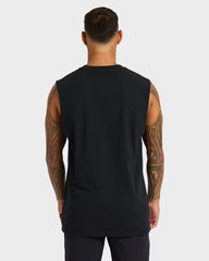 Man wearing a black sleeveless shirt with tattoos on arms against a white background