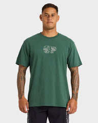 Man wearing a green t-shirt with a logo on a white background
