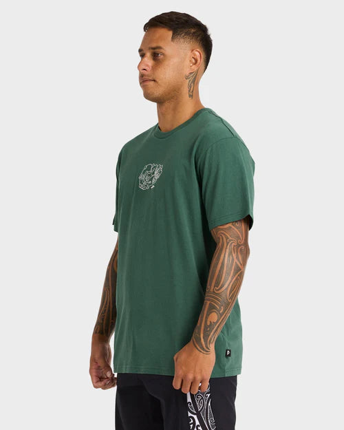 Man wearing a green t-shirt with a logo on a white background