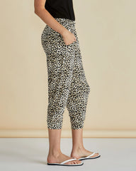Person wearing leopard print pants on a beige background