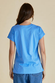 Person wearing a blue t-shirt on a beige background