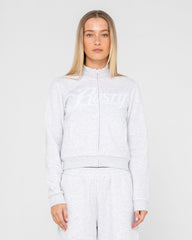 Woman wearing a light gray tracksuit on a white background