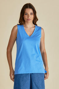 Woman wearing a blue sleeveless top against a beige background