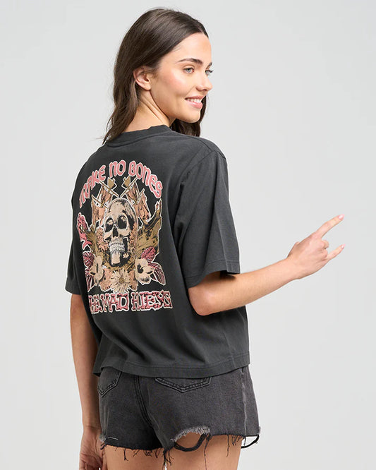 Woman wearing a black t-shirt with a graphic design on the back, pointing to the design.
