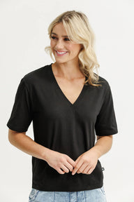 Lady wearing a black V Neck tee with white background
