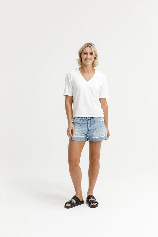 Woman wearing a white t-shirt and denim shorts on a white background