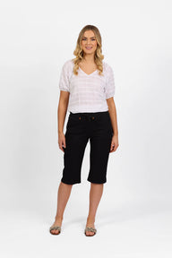 Woman wearing Vassalli Below Knee Skinny Leg Elastic Waist Pant with white top and white background