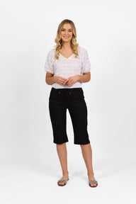 Woman wearing Vassalli Below Knee Skinny Leg Elastic Waist Pant with white top and white background
