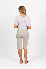 Woman wearing Vassalli Below Knee Skinny Leg Elastic Waist Pant in stone with white top and white background