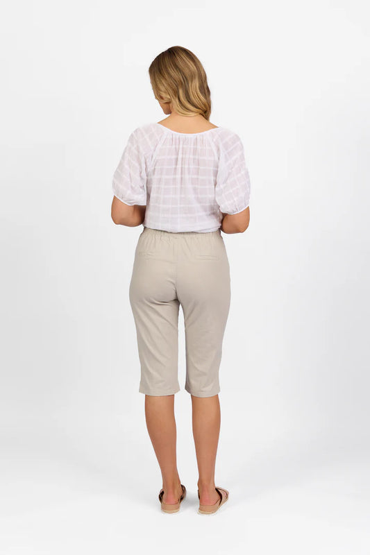 Woman wearing Vassalli Below Knee Skinny Leg Elastic Waist Pant in stone with white top and white background