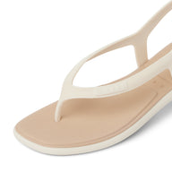 Beige sandal with white strap on a light gray background