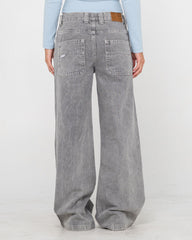 Person wearing gray wide-leg jeans on a white background