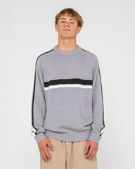 Person wearing a gray sweater with black and white stripes on a plain background