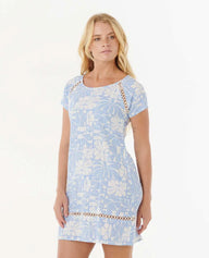 Woman wearing a light blue floral dress with lace details on a white background