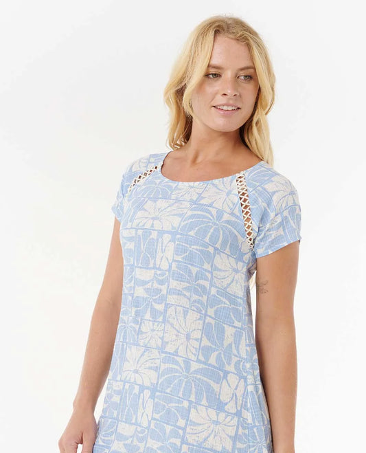 Woman wearing a light blue patterned dress with a white background