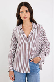 Woman wearing a striped shirt and jeans on a white background