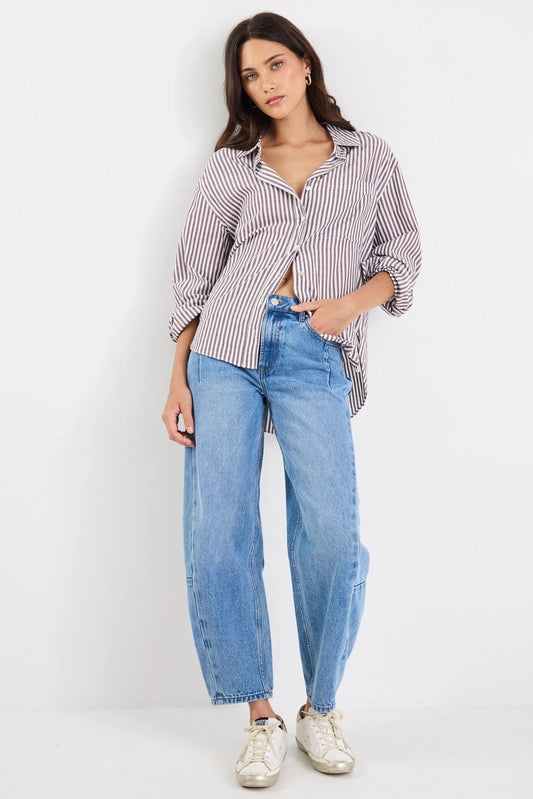 Woman wearing a striped shirt and blue jeans on a white background