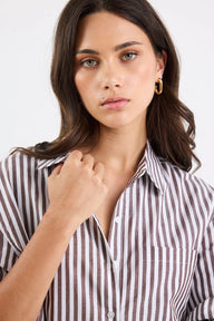 Woman wearing a striped shirt against a plain background