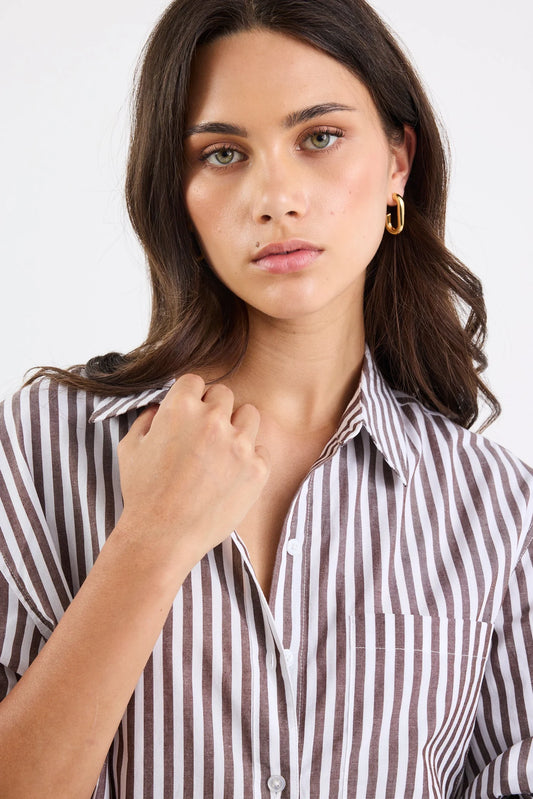 Woman wearing a striped shirt against a plain background