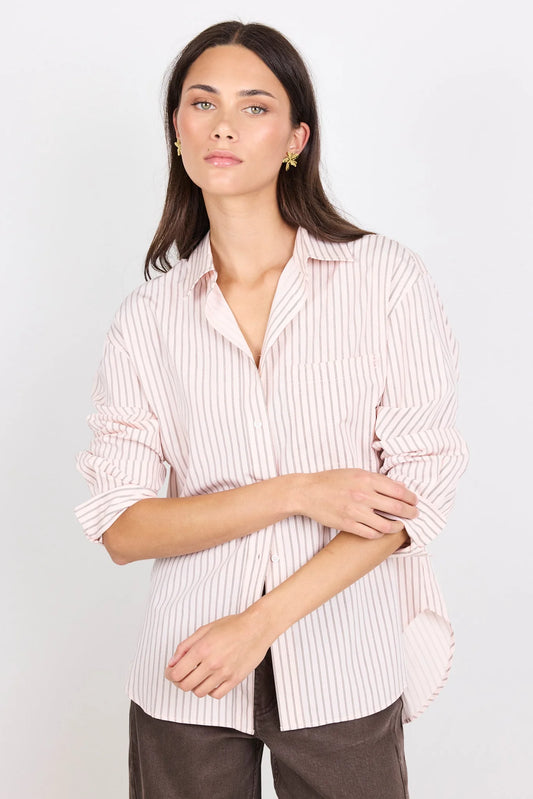 Woman wearing a striped shirt against a plain background