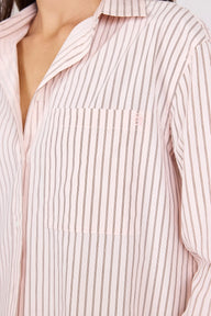 Close-up of a person wearing a light pink button-up shirt with thin vertical dark stripes and a chest pocket.