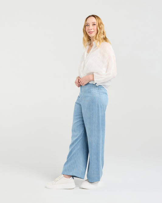 Woman wearing Zafina Heidi white blouse and light blue striped pants on a white background
