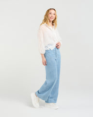 Woman wearing Zafina Heidi white blouse and light blue striped pants on a white background