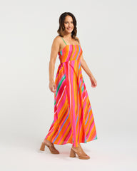 Woman wearing a colorful striped dress on a white background