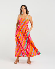 Woman wearing a colorful striped dress on a white background