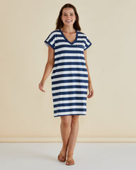 Woman wearing a blue and white striped dress on a beige background