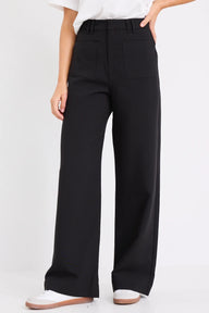 Person wearing black wide-leg pants on a white background