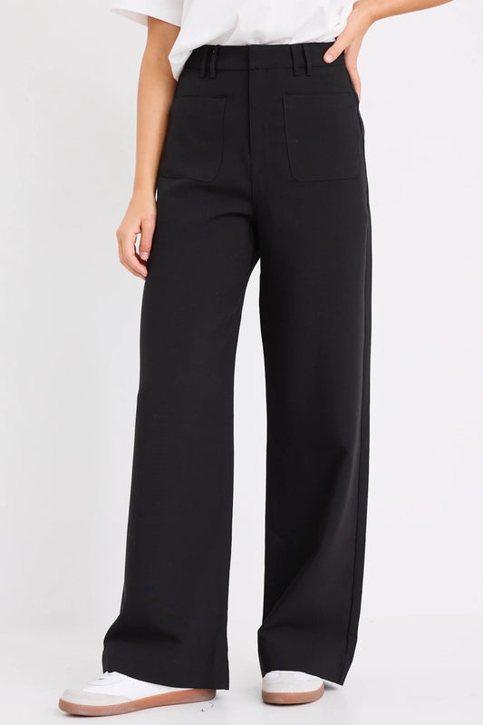 Person wearing black wide-leg pants on a white background