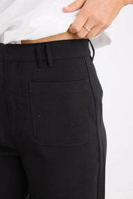 Close-up of black pants with a pocket on a white background