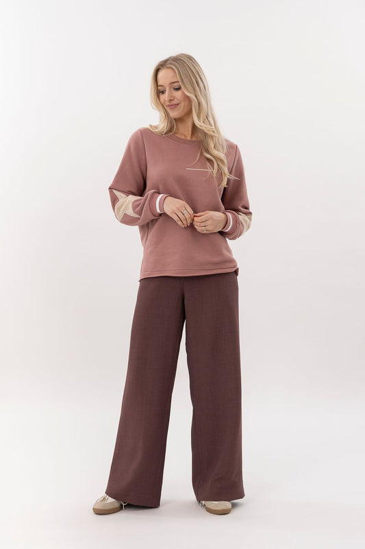 Woman wearing a matching pink and brown outfit on a white background