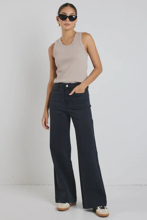 Woman wearing a beige sleeveless top and Amoung the Brave Zoey black wide-leg pants against a white background