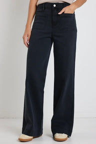 Woman wearing a beige sleeveless top and Amoung the Brave Zoey black wide-leg pants against a white background