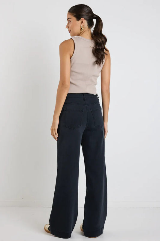 Woman wearing a beige sleeveless top and Amoung the Brave Zoey black wide-leg pants against a white background