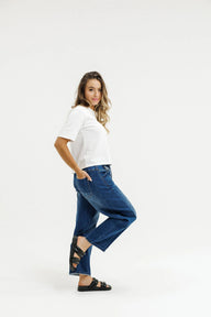 Woman wearing a white top and blue jeans on a white background