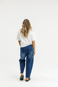 Person wearing blue jeans and a white shirt on a white background