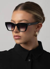 Woman wearing black sunglasses with a blurred background
