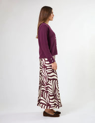 Woman wearing a purple top and zebra-patterned skirt on a white background