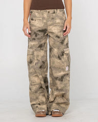 Camouflage pants worn by a person on a plain background